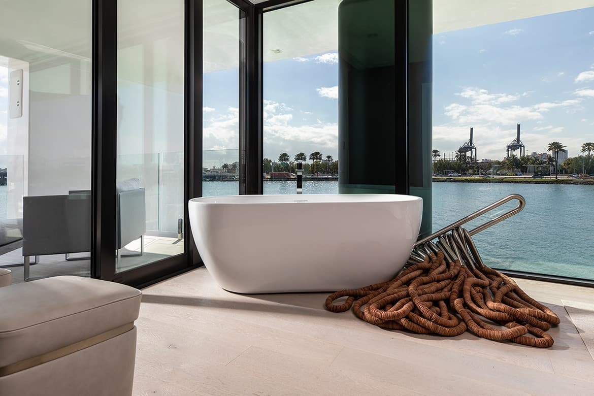 A bathroom with bathtub overlooking a waterfront view