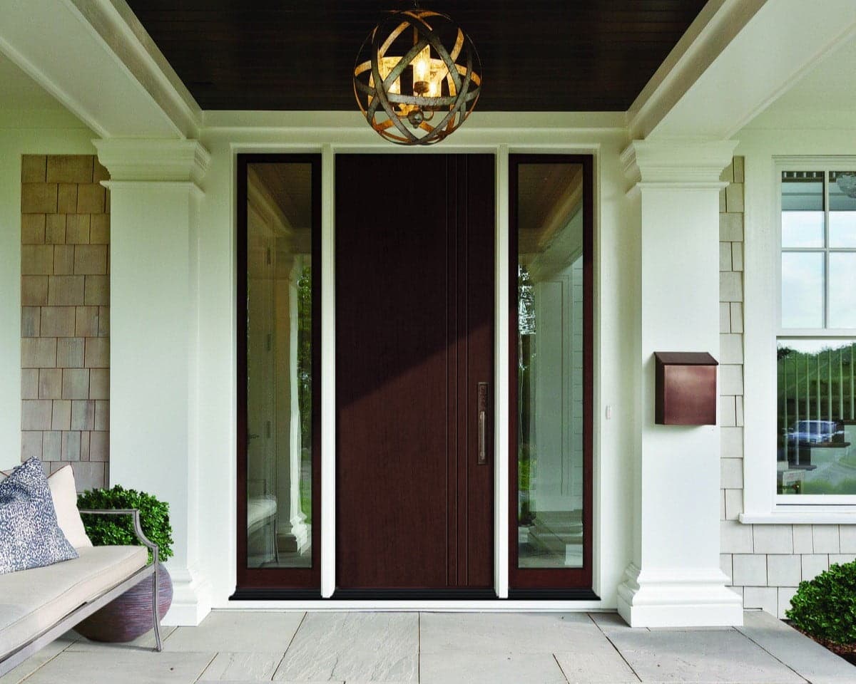 A stylish front entryway featuring a dark wooden door flanked by narrow glass panels.