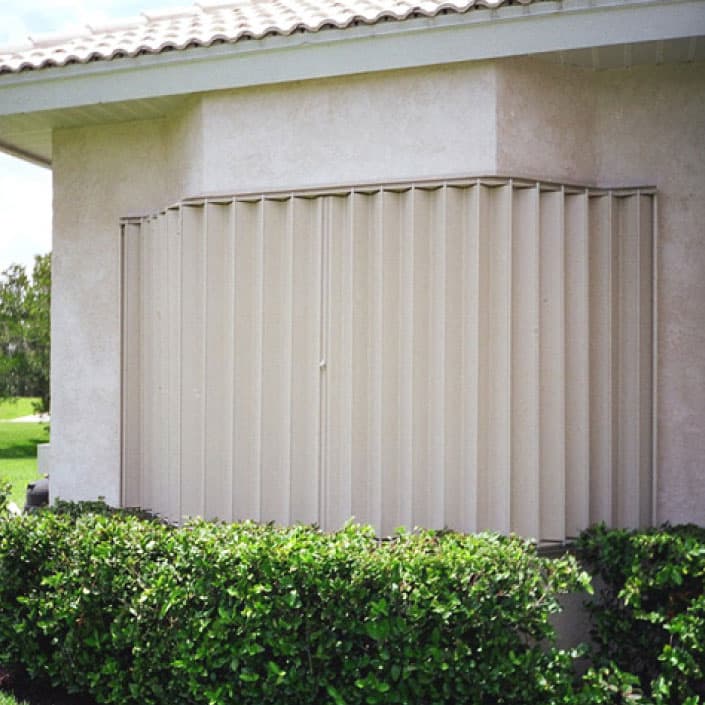 Exterior view of a home with metal shutters covering a window.