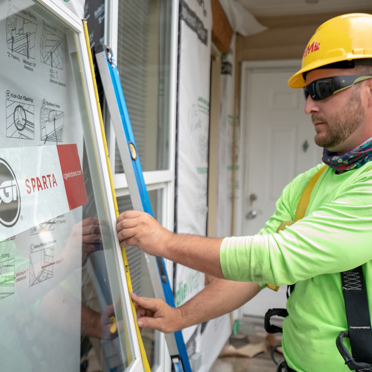 A man is measuring a window.