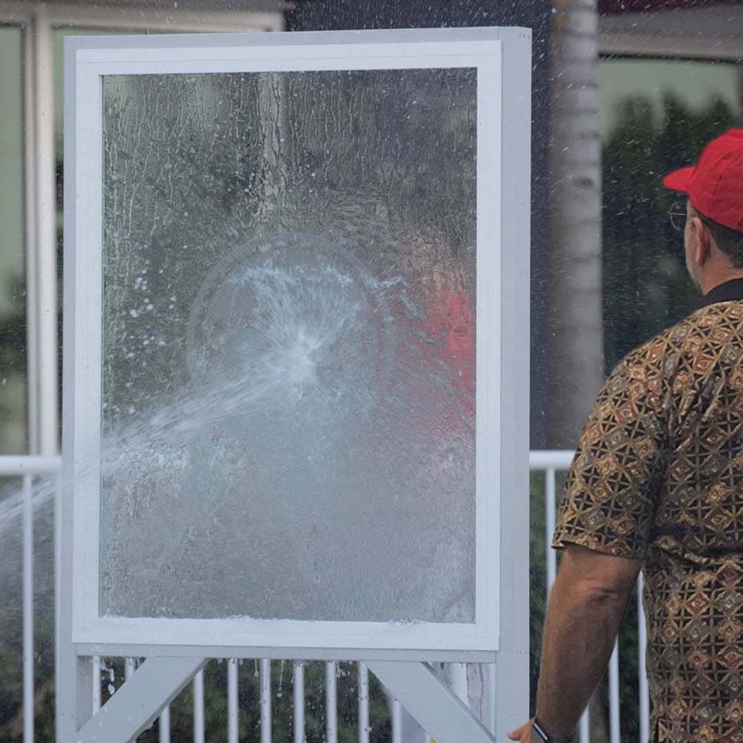 a man spraying water on a window