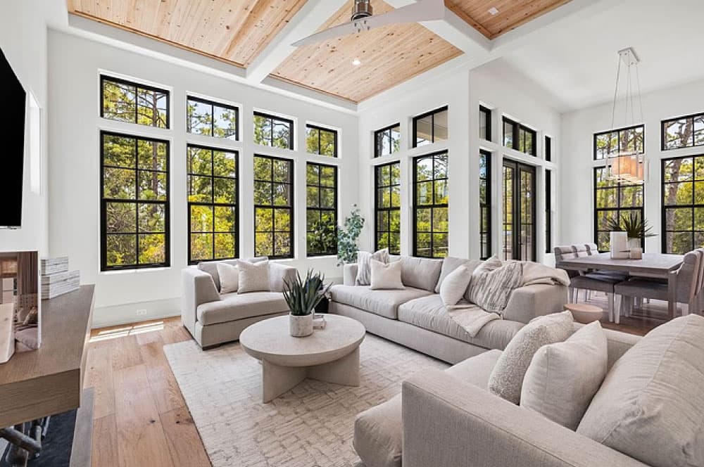 Luxurious living and dining area with tall black-framed windows